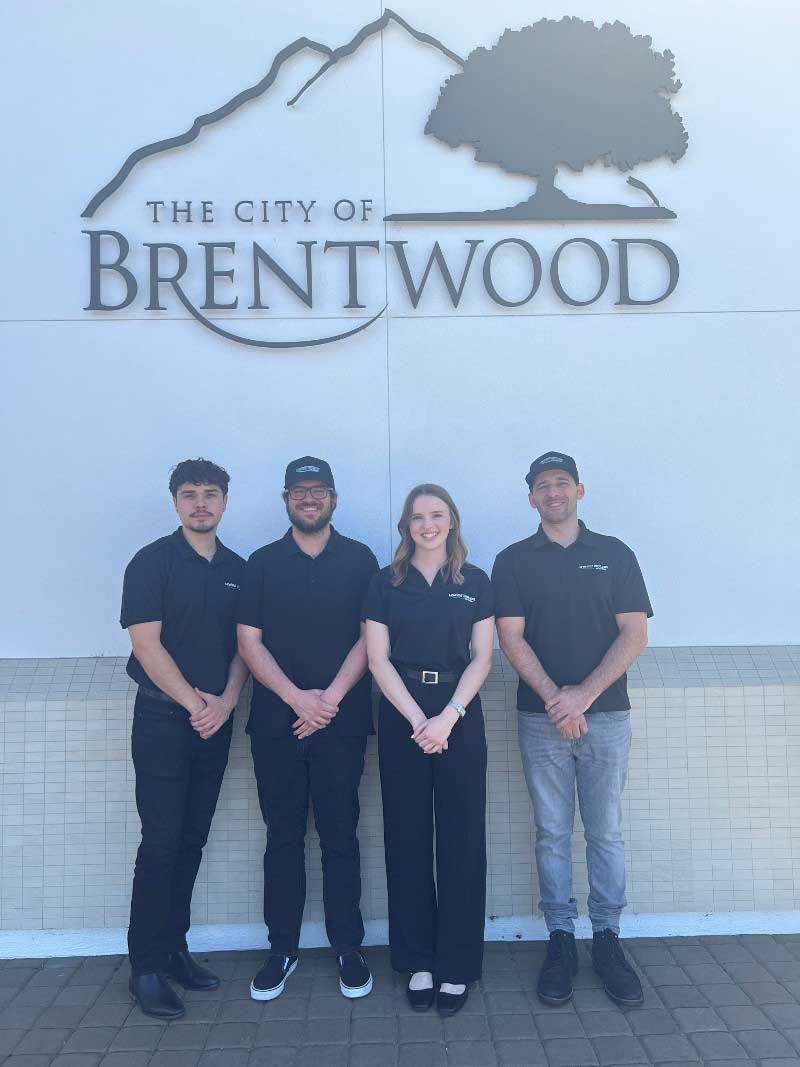 A group of people standing in front of a brentwood sign
