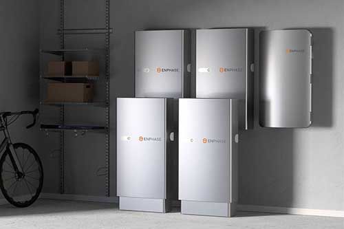 A bicycle is parked in a garage next to a row of batteries.