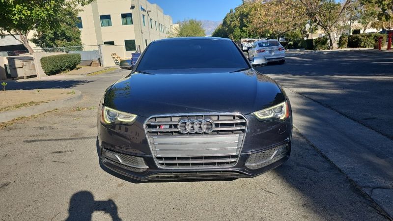 Black Audi car parked on a street; front view.