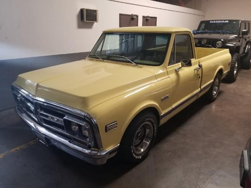 Yellow classic Chevrolet pickup truck parked in an indoor garage.