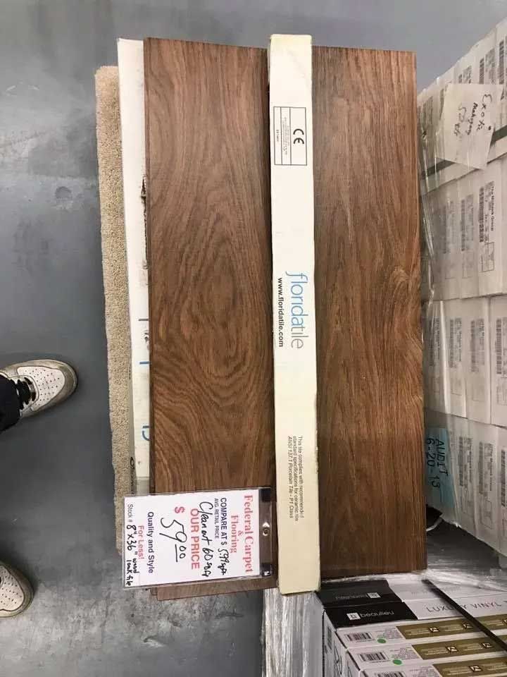 Flooring samples: wood planks, carpet, and price tag on a pallet.