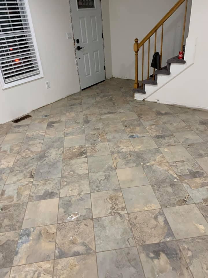 Interior view with square patterned tiles, door, staircase, and window.