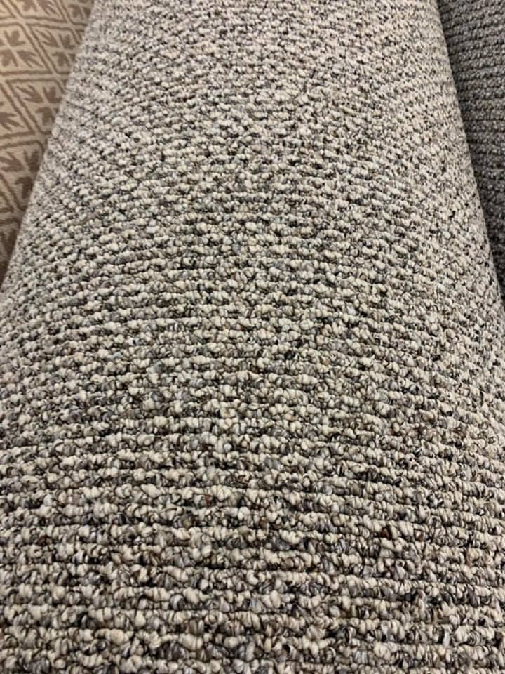 Rolled-up gray and white speckled carpet.