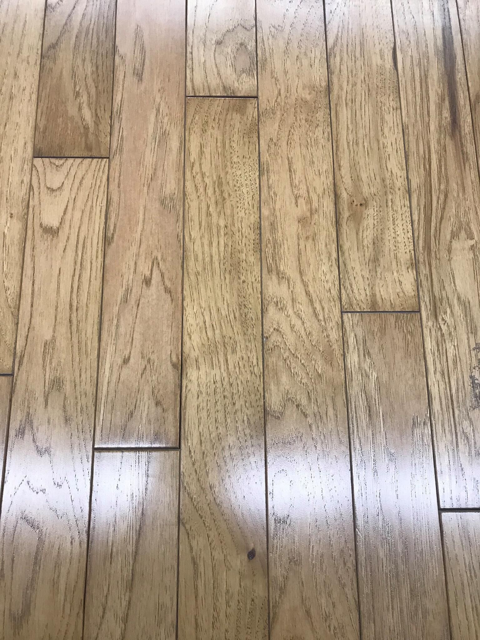 Light-colored hardwood floor, made of planks with visible grain, with a shiny finish.