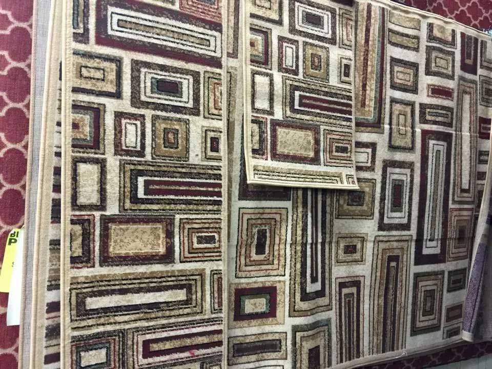 Carpets with geometric rectangles in brown, tan, and burgundy, displayed in a store.