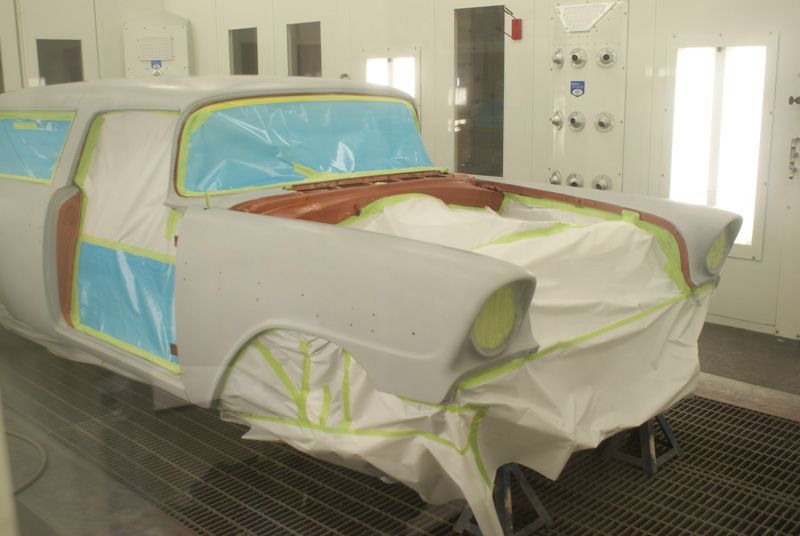 A car is being painted in a paint booth.