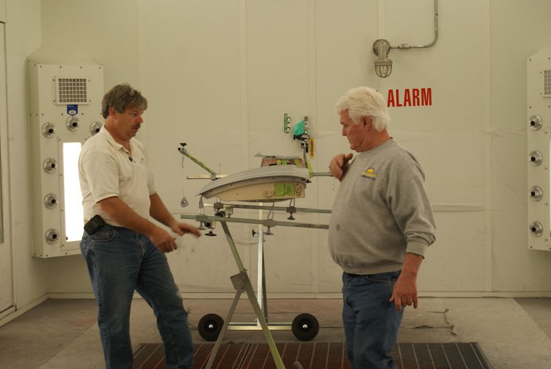 Two men are standing in a room with a sign that says alarm