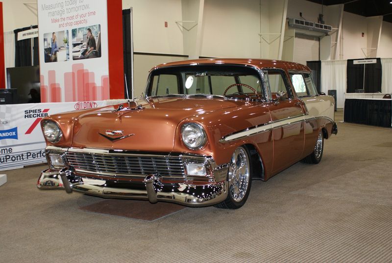 A brown chevrolet station wagon is parked in a showroom