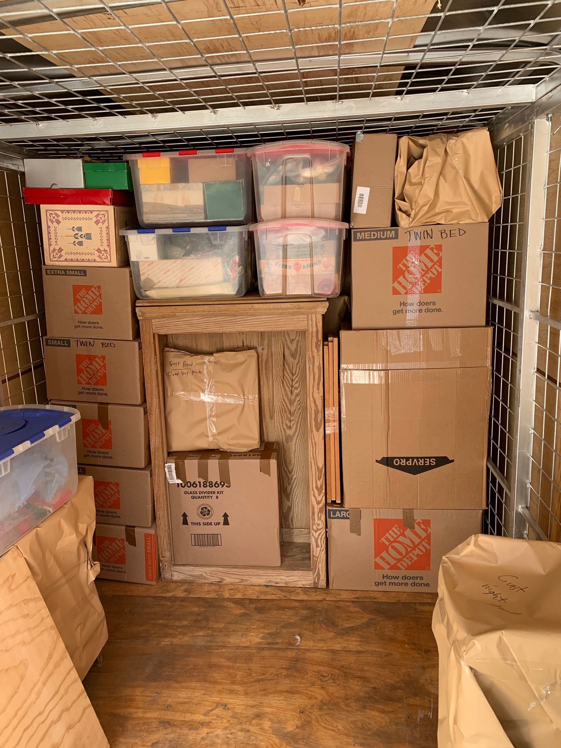 The inside of a moving truck filled with boxes and plastic bins.