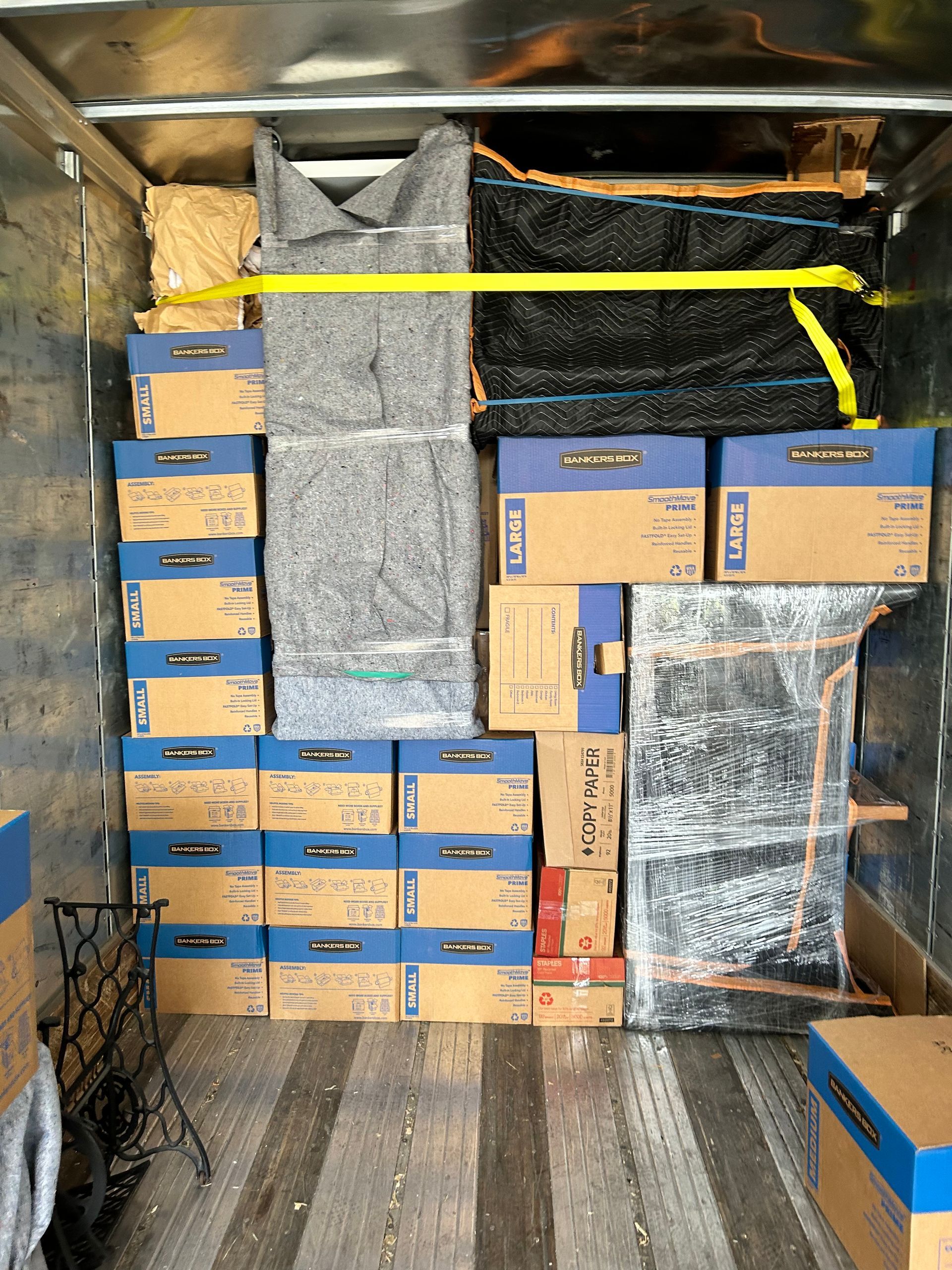 The back of a moving truck filled with boxes and a measuring tape.