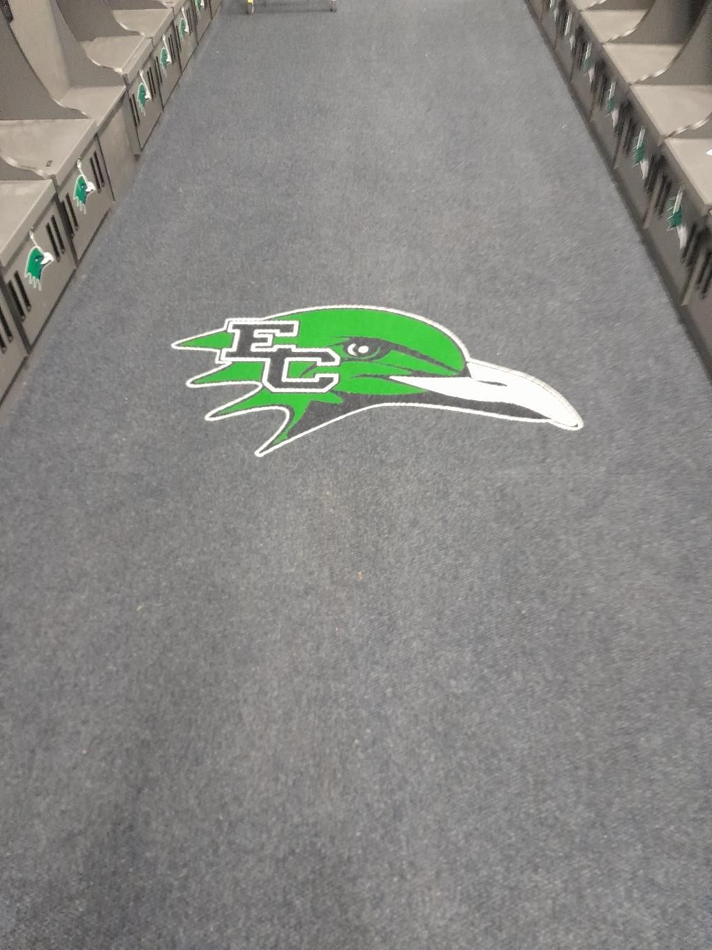 Arow of lockers with a green and white logo on the floor.