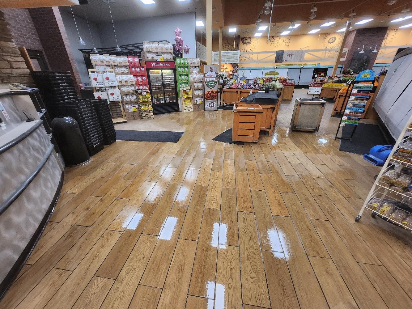 The inside of a grocery store with a wooden floor.