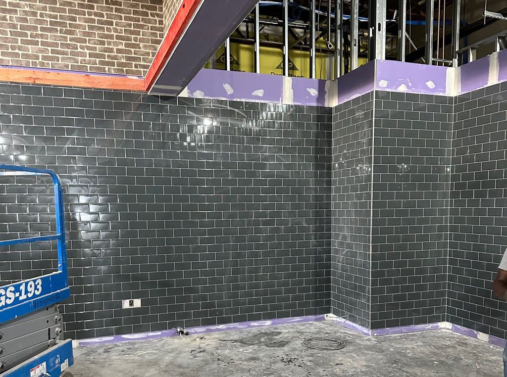 A room with a brick wall and a blue lift in the corner.