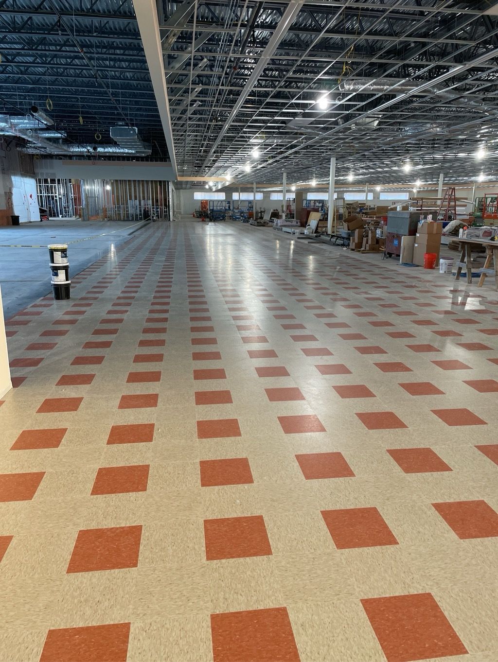 A large empty room with red and white tiles on the floor.