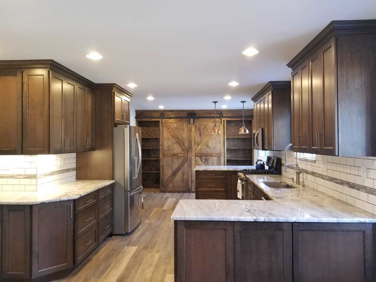 A kitchen with wooden cabinets and a sliding barn door
