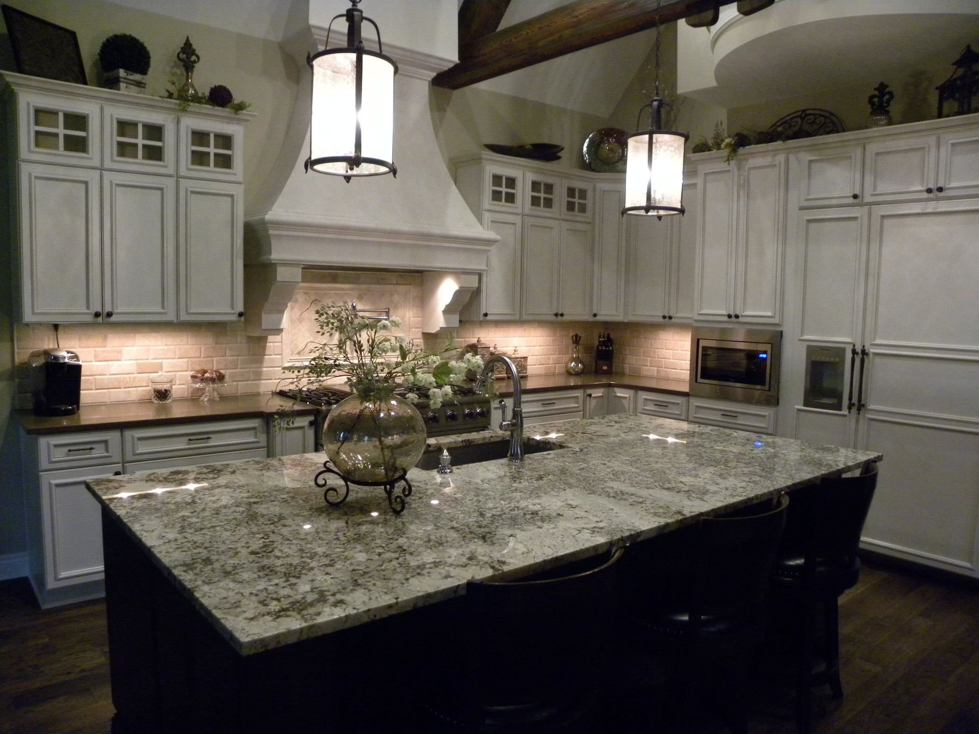 A kitchen with white cabinets and granite counter tops