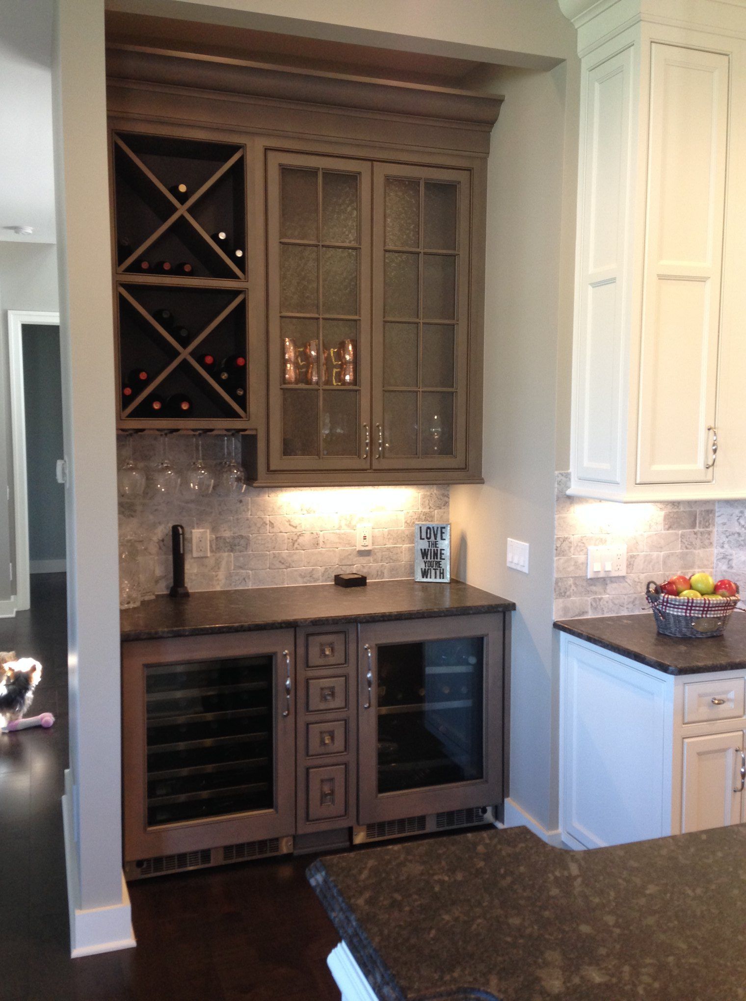 A kitchen with white cabinets and a wine cooler