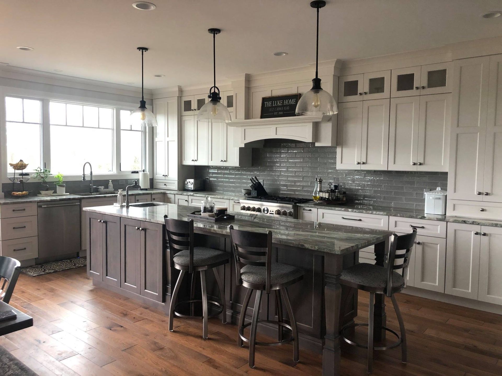 A kitchen with white cabinets and a large island in the middle.