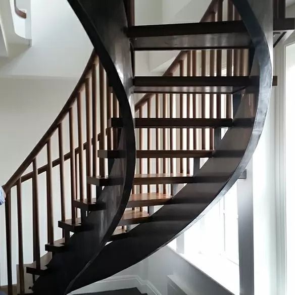 A wooden spiral staircase with a metal railing