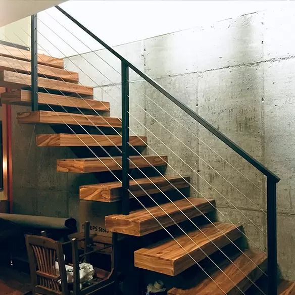 A wooden staircase with a metal railing in a room