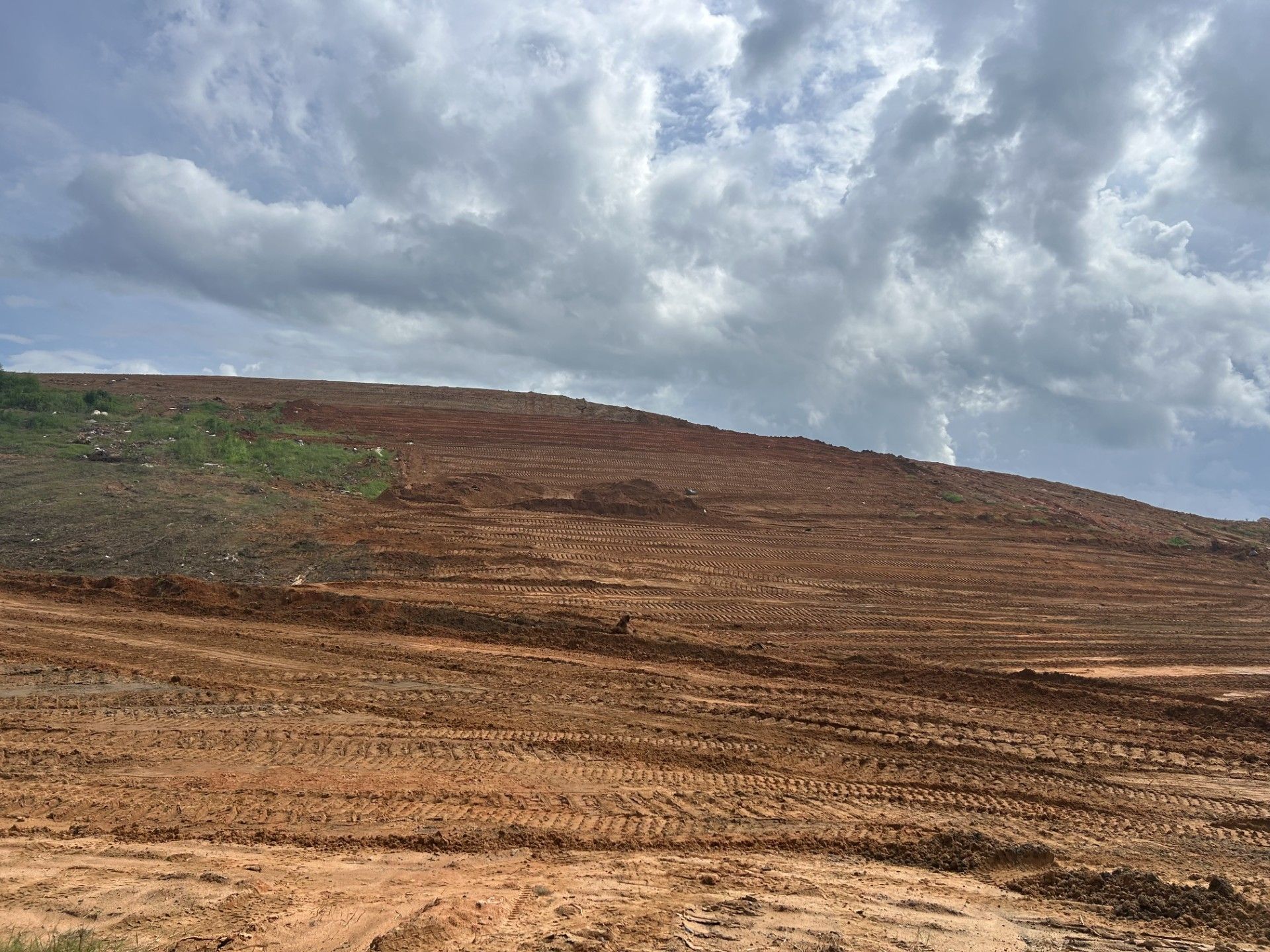 A dirt hill with a cloudy sky in the background.