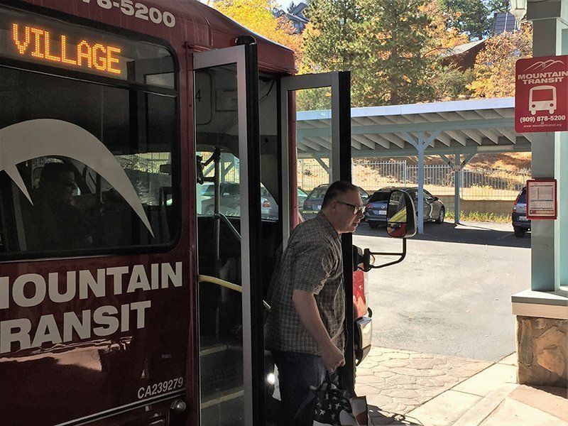A man is getting on a mountain transit bus