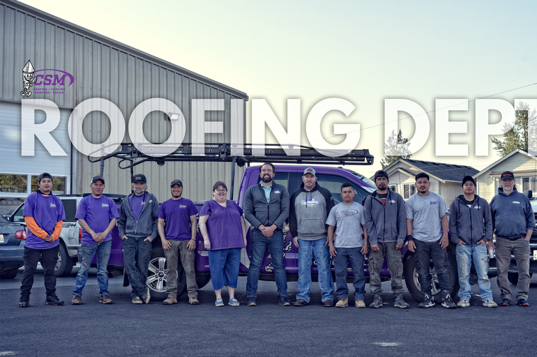 Team photo in front of a building and van. 