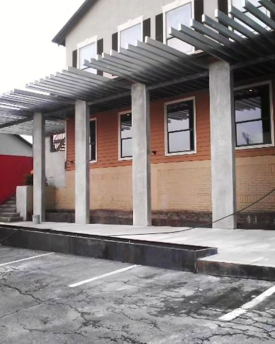 A building with a lot of windows and a parking lot in front of it.