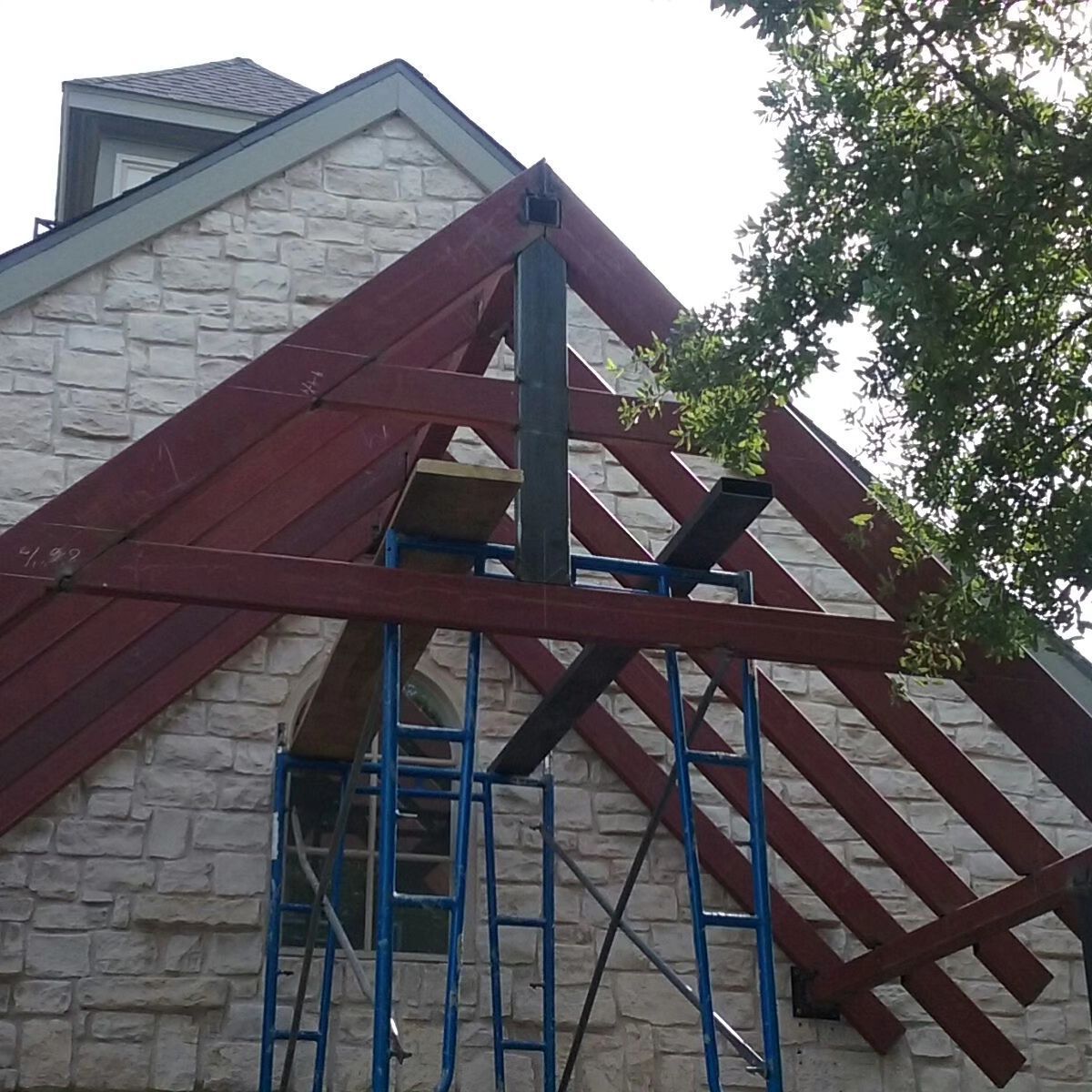 A wooden structure is being built on top of a brick building.