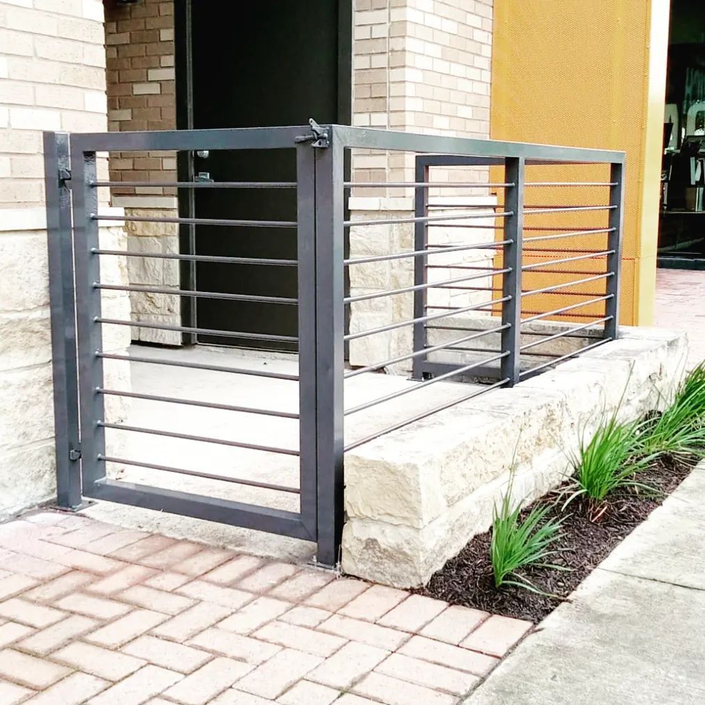 A brick building with a black gate in front of it.