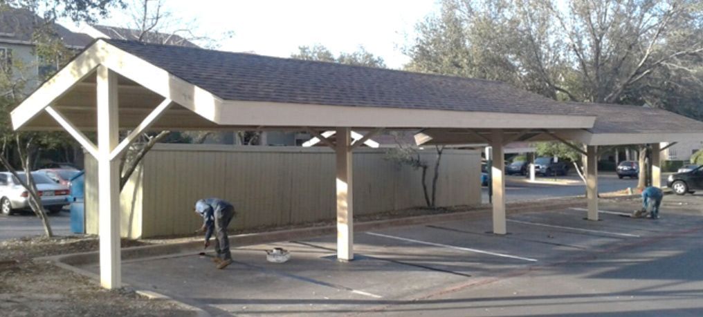 A carport is being built in a parking lot.