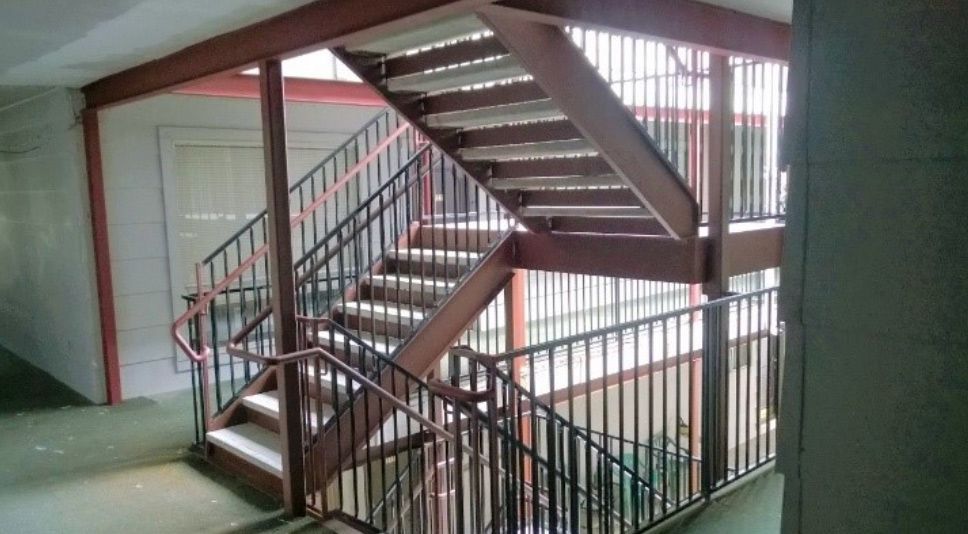 A staircase with a metal railing in a building.