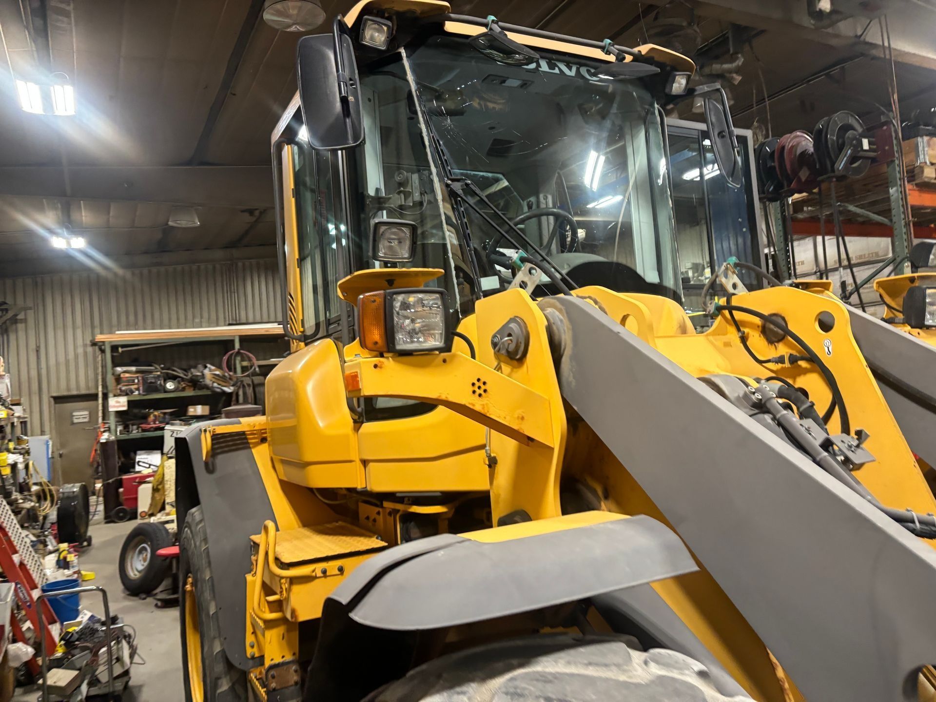 Yellow Volvo wheel loader in a workshop.
