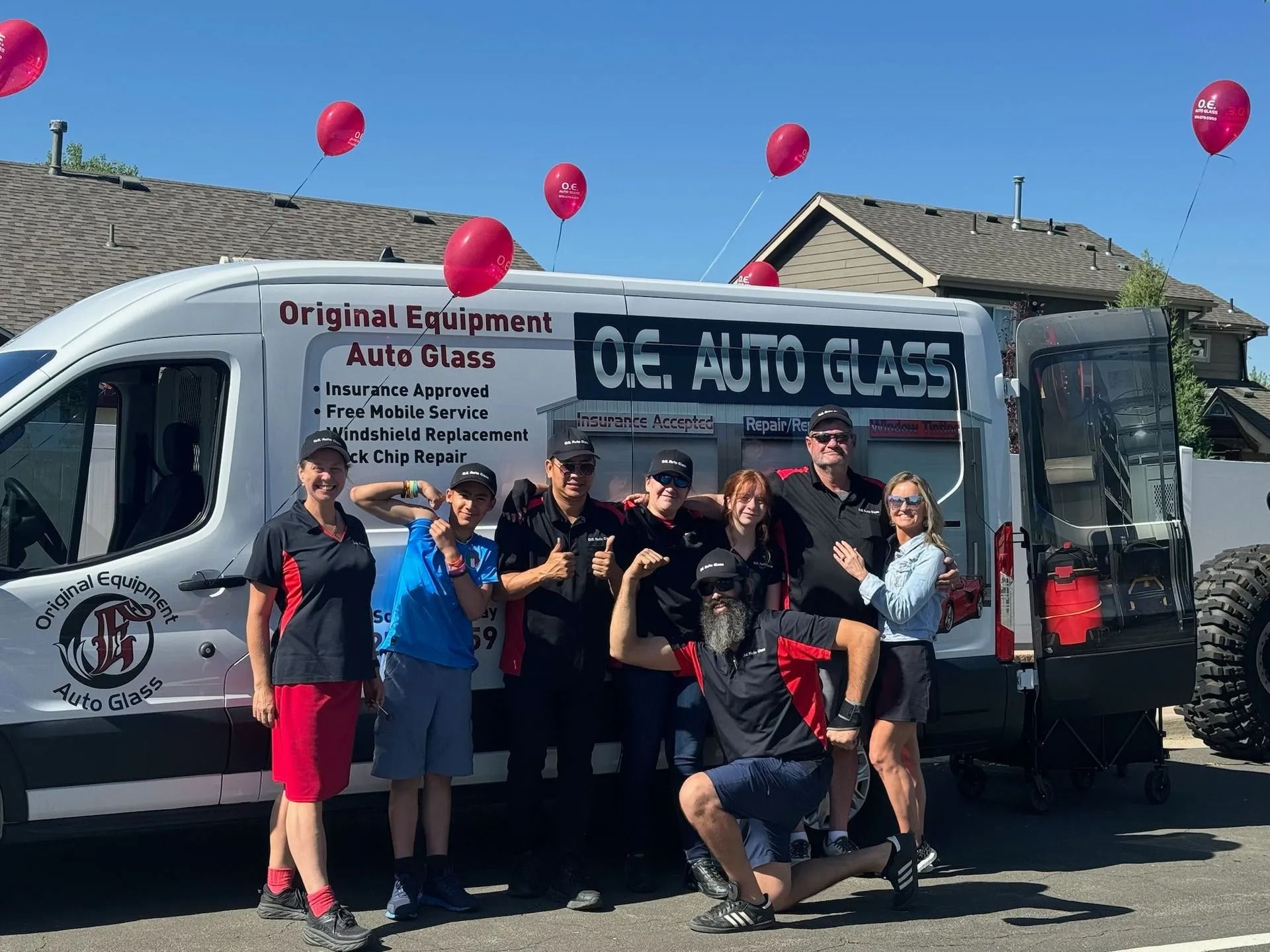 A group of people poses with a van that reads 