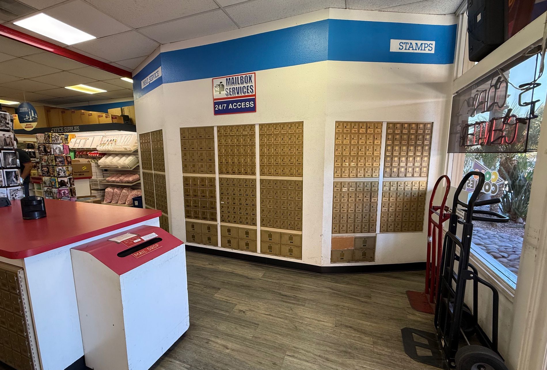 Interior of a storage facility: rows of small storage units, white walls, and a red service counter.