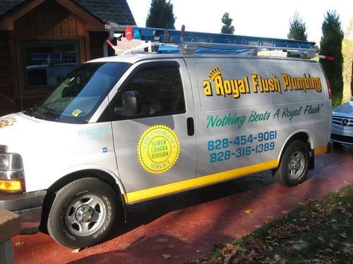 White fish-cleaning van with colorful “Royal Flush Plumbing” lettering parked by a brick driveway and house