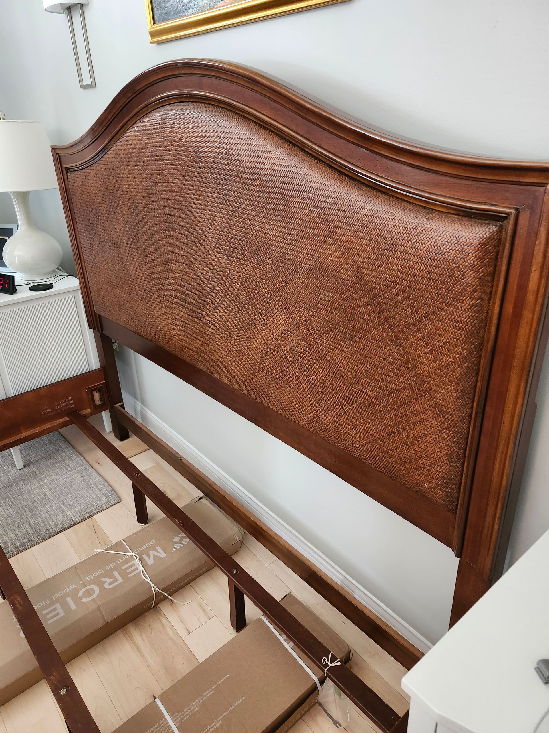 Brown woven-texture headboard on a wooden bed frame, against a gray wall.
