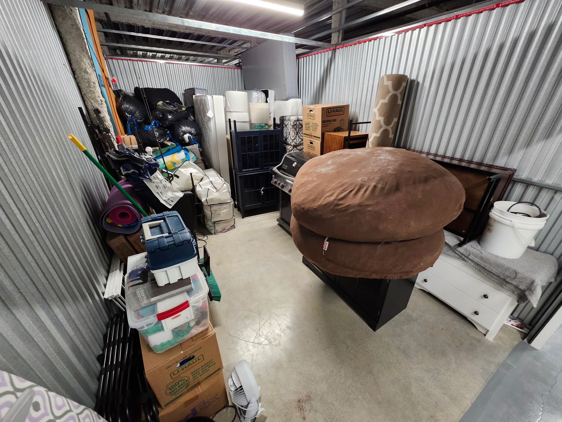 Storage unit filled with furniture, boxes, and household items.