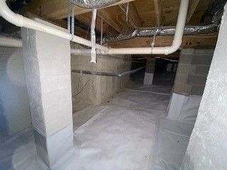 A basement with a lot of pipes hanging from the ceiling.