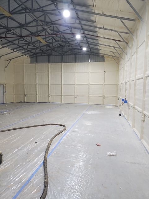 A large empty warehouse with newly installed spray foam