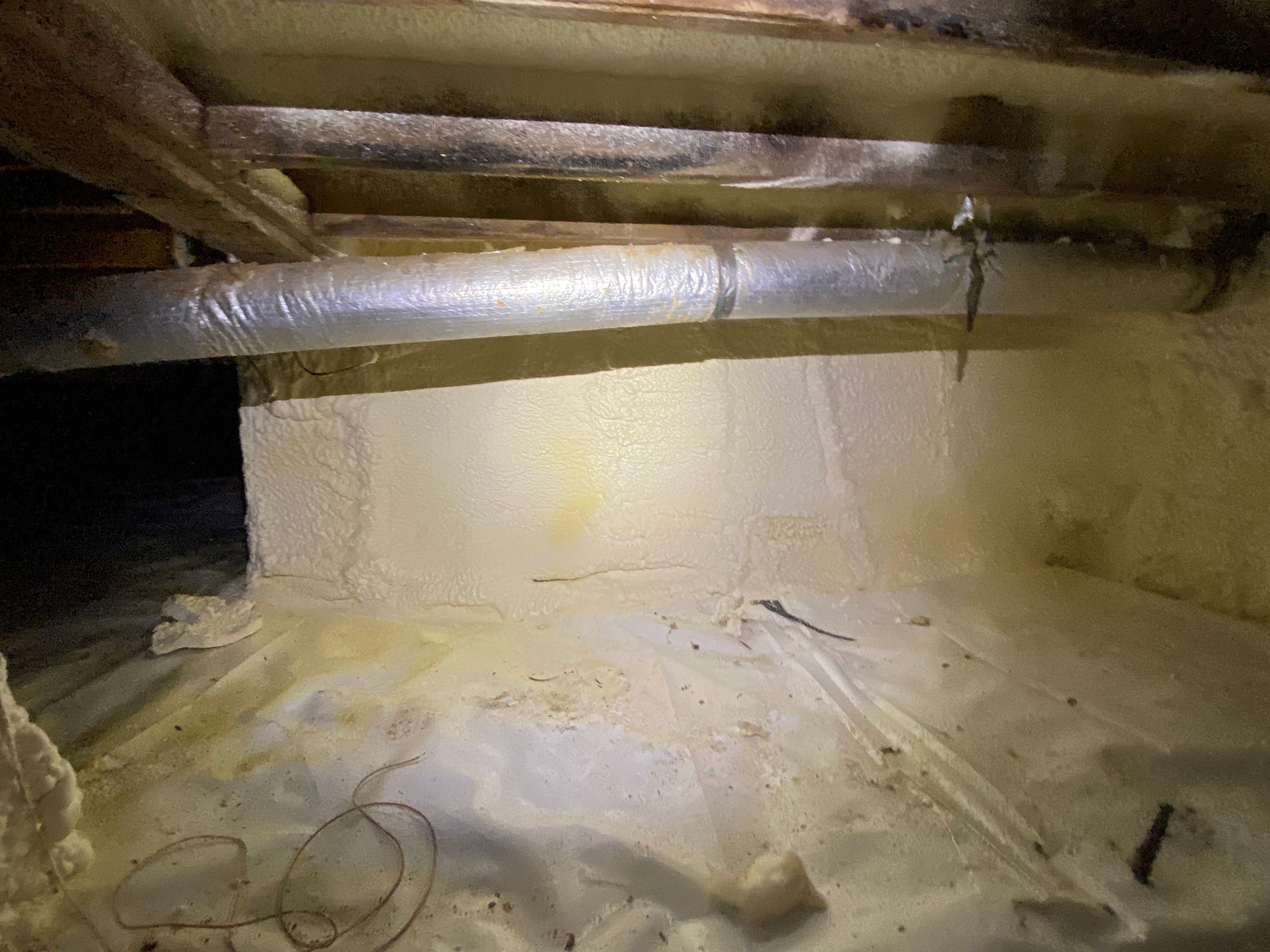 A dirty basement with a lot of foam on the floor.