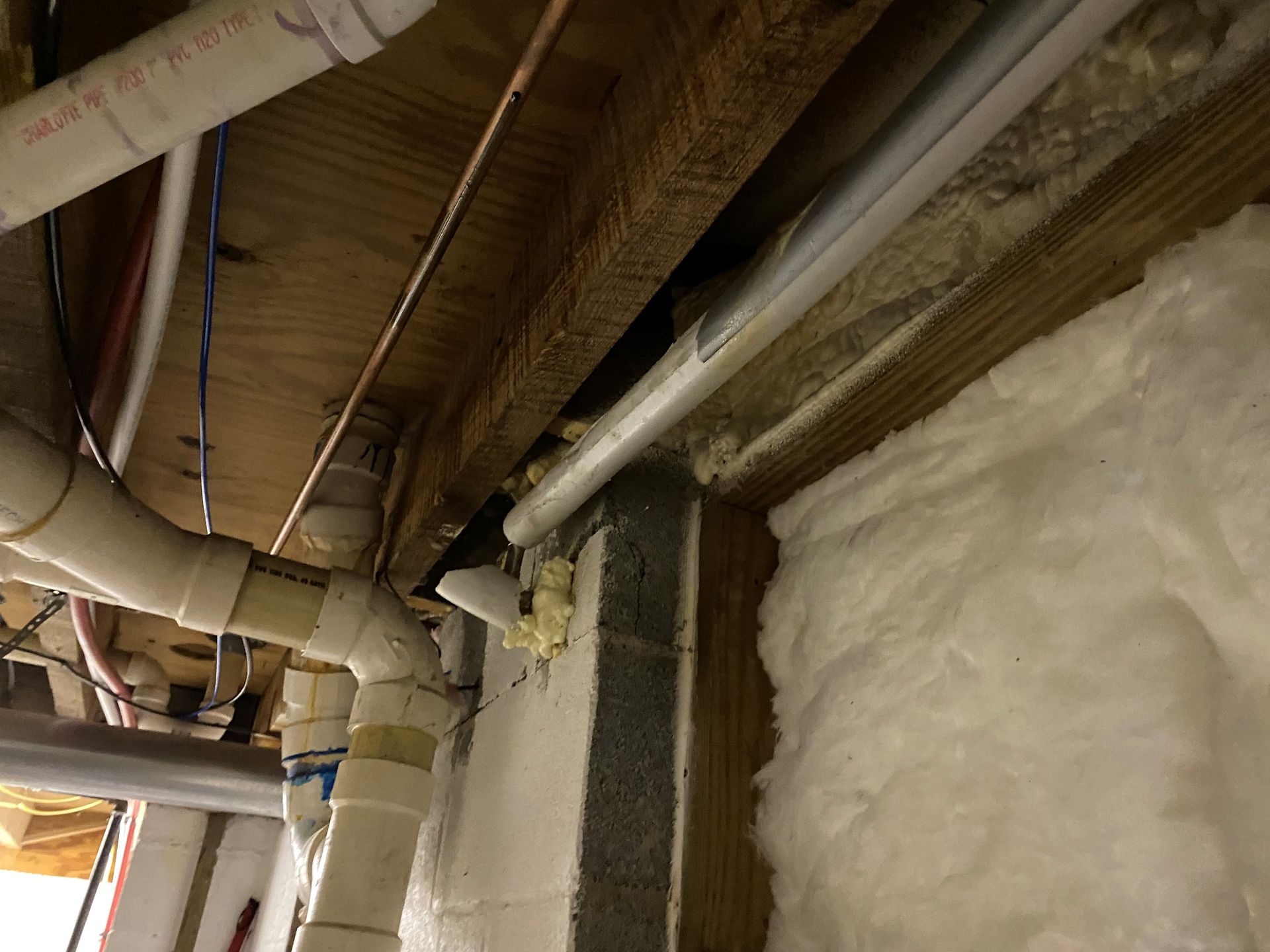 A bunch of pipes are hanging from the ceiling of a building.