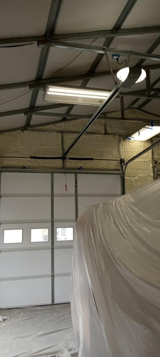 A garage door is open and covered in plastic.