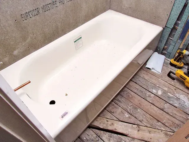 A white bathtub is being installed