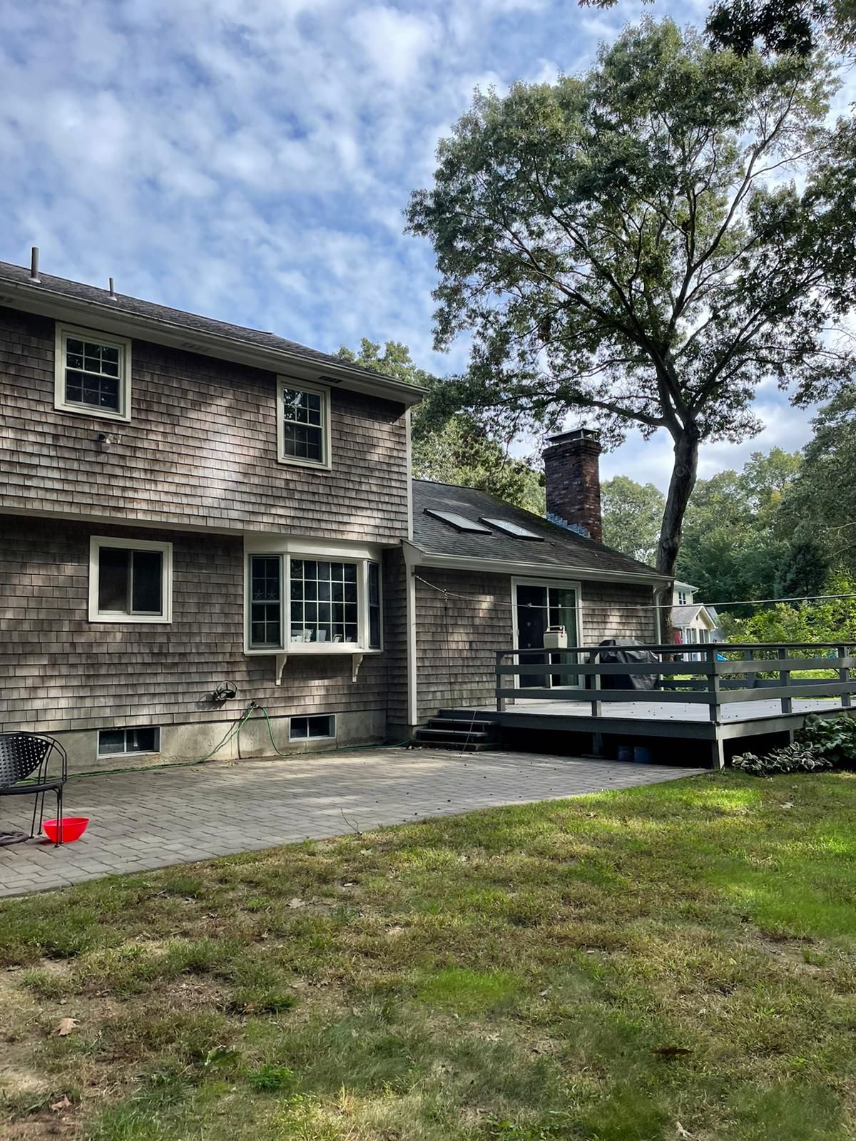A large house with a large deck in the backyard.