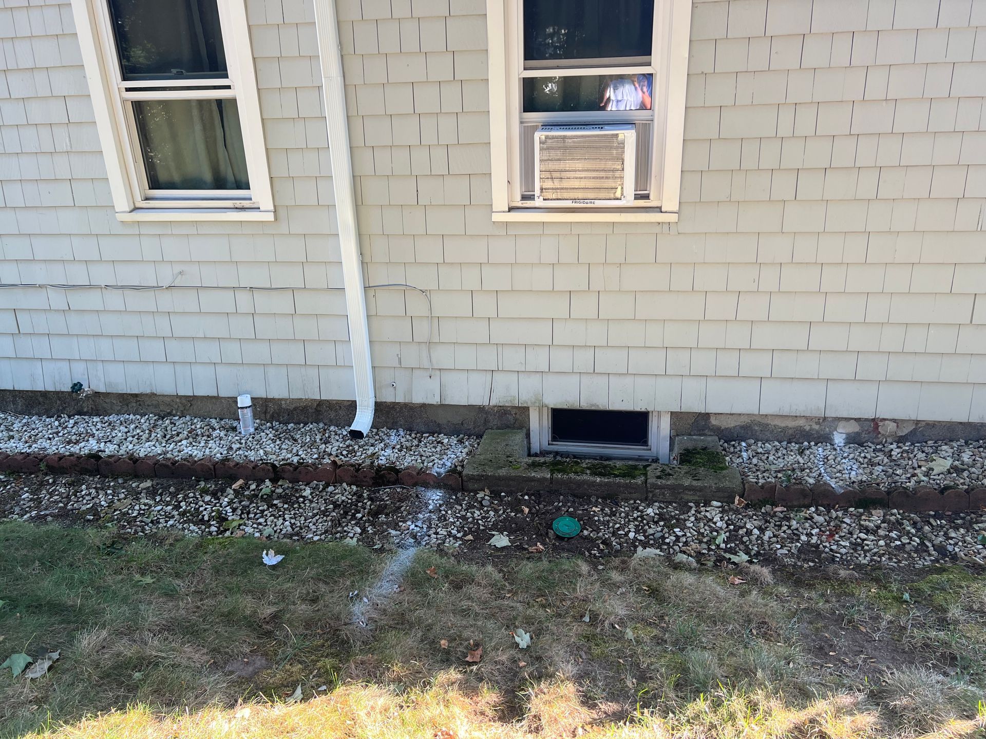Gray house with white trim, windows, AC unit, and gutter