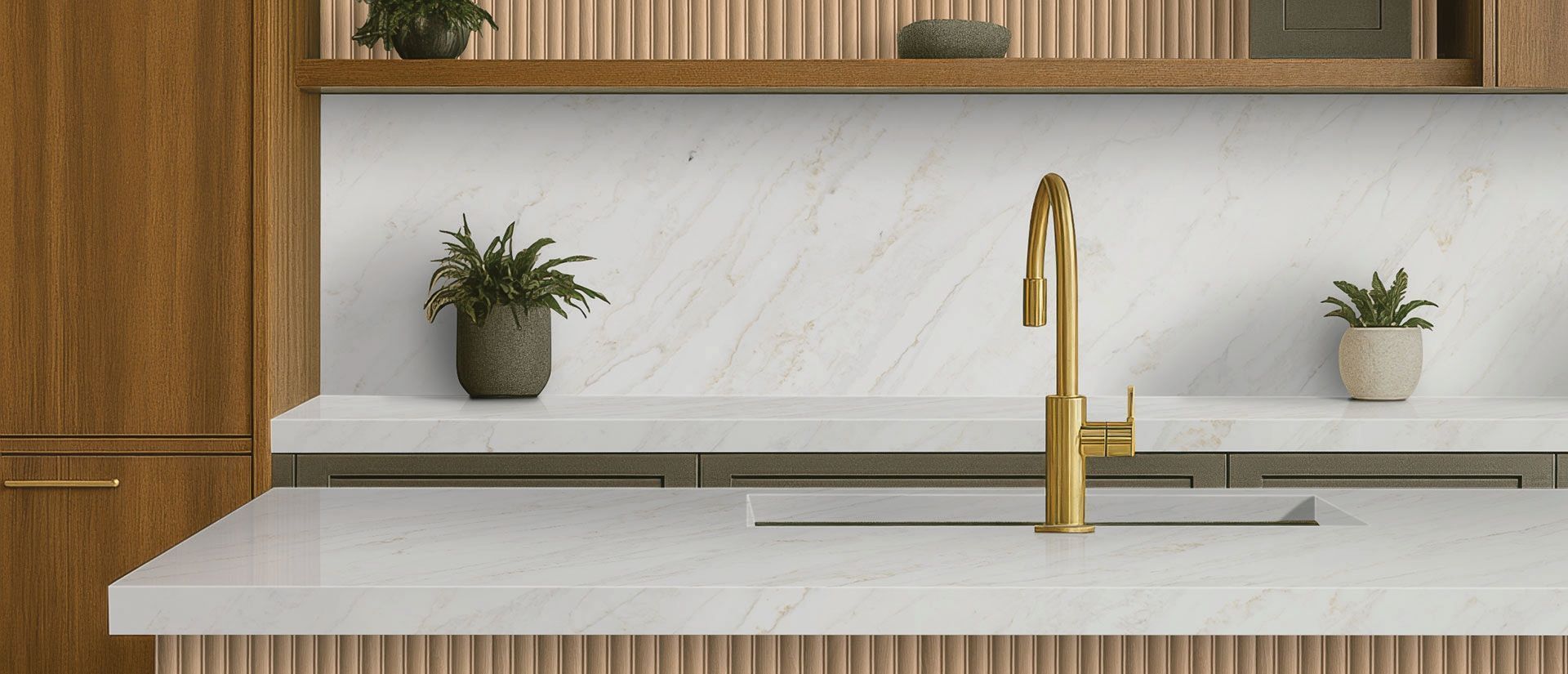Modern kitchen with white countertop, gold faucet, wood cabinets, and small potted plants