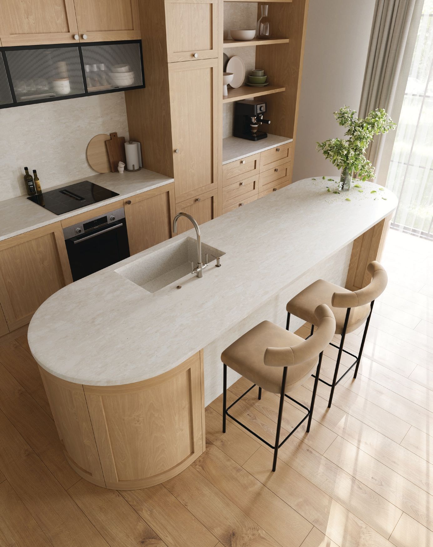 Modern kitchen with a long white island, two stools, and light wood cabinets by a bright window.