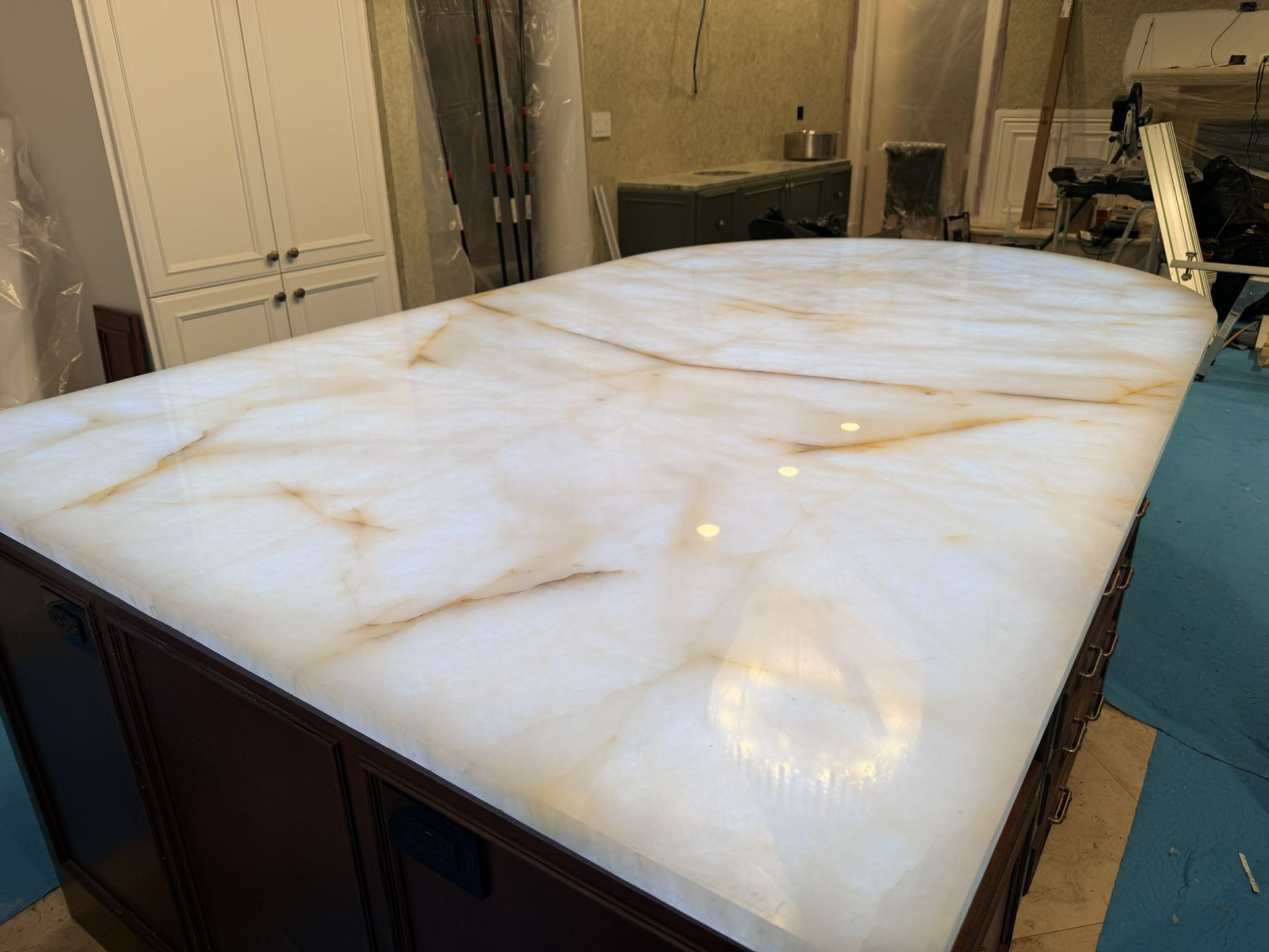 White marble countertop with subtle gold veining on a dark cabinet base in a kitchen-like room
