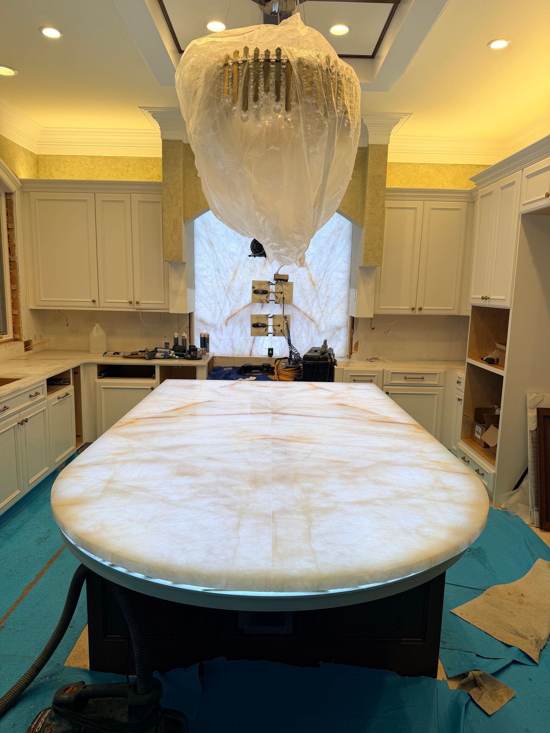 Destroyed kitchen with overturned island and collapsed chandelier, debris scattered on the floor